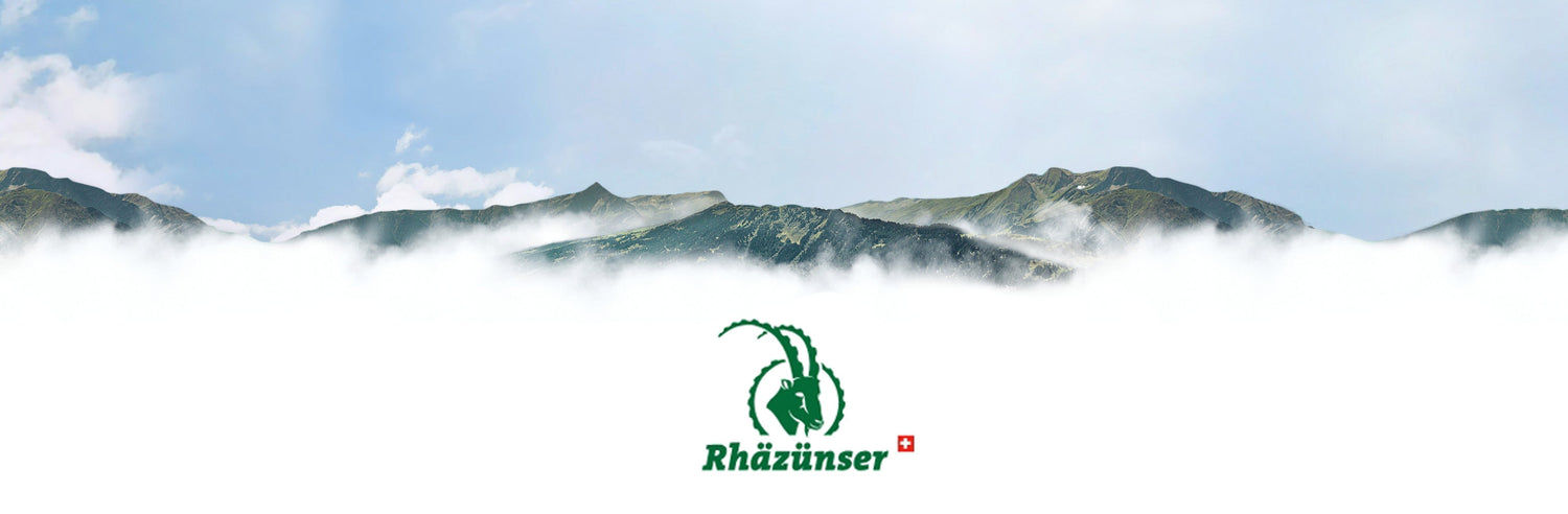 DE: Rhäzünser Logo vor den Bündner Bergen mit Wolken. FR: Logo Rhäzünser devant les montagnes des Grisons avec des nuages. IT: Logo Rhäzünser davanti alle montagne dei Grigioni con nuvole.