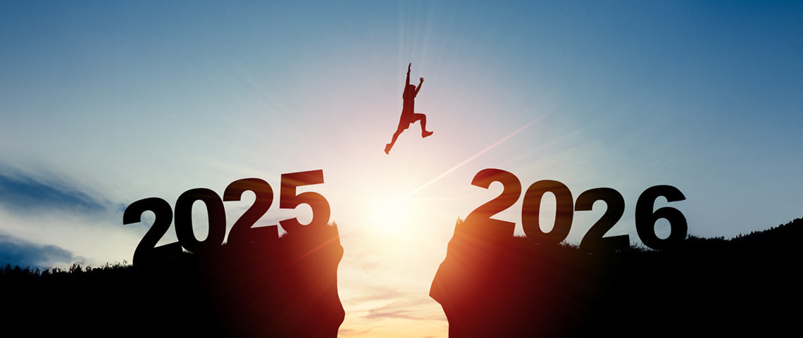 Person springt von 2025 zu 2026 im Sonnenaufgang.
