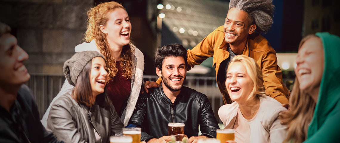 DE: Freundesgruppe lacht und trinkt Bier zusammen im Winter FR: Groupe d'amis riant et buvant de la bière ensemble en hiver IT: Gruppo di amici ride e beve birra insieme in inverno EN: Group of friends laughing and drinking beer together in winter