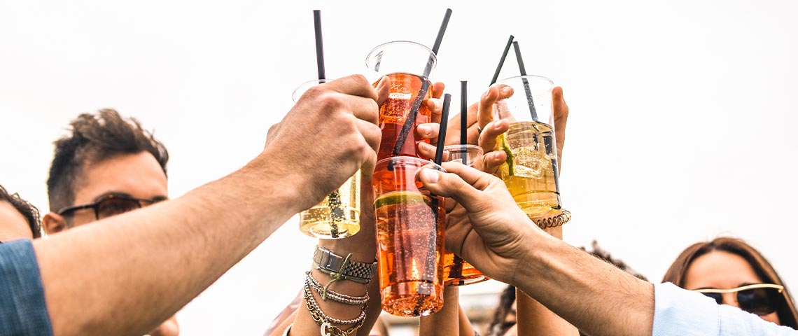 DE: Vier Hände stossen mit bunten Longdrinks an FR: Quatre mains trinquant avec des boissons longues colorées IT: Quattro mani brindano con drink colorati EN: Four hands toasting with colourful long drinks