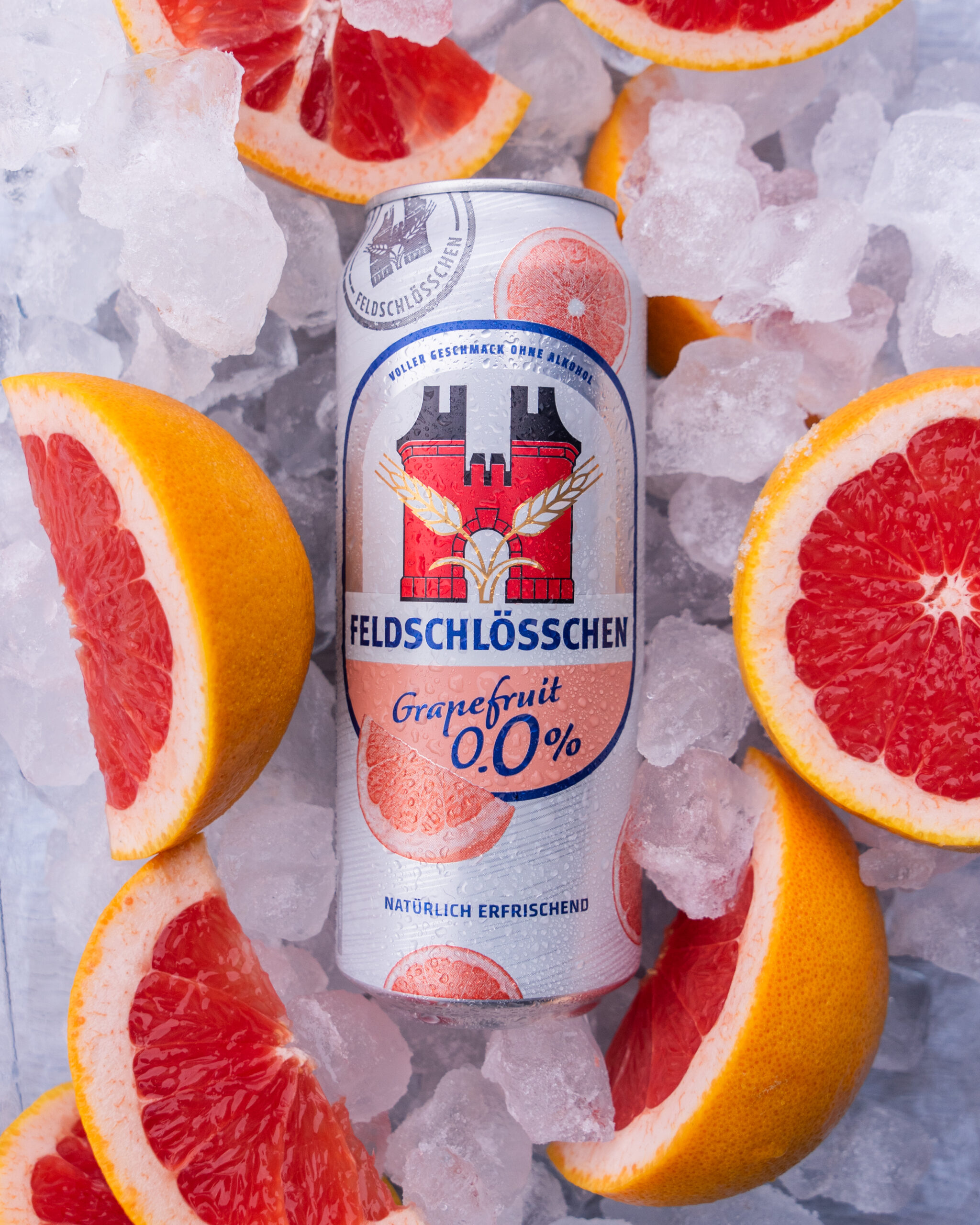 DE: Feldschlösschen Panaché 0.0% Grapefruit Dose auf Eis mit Grapefruitschnitzen; FR: Canette de Feldschlösschen Panaché 0.0% Pamplemousse sur glace avec des quartiers de pamplemousse; IT: Lattina di Feldschlösschen Panaché 0.0% Pompelmo su ghiaccio con spicchi di pompelmo; EN: Feldschlösschen Panaché 0.0% Grapefruit can on ice with grapefruit wedges